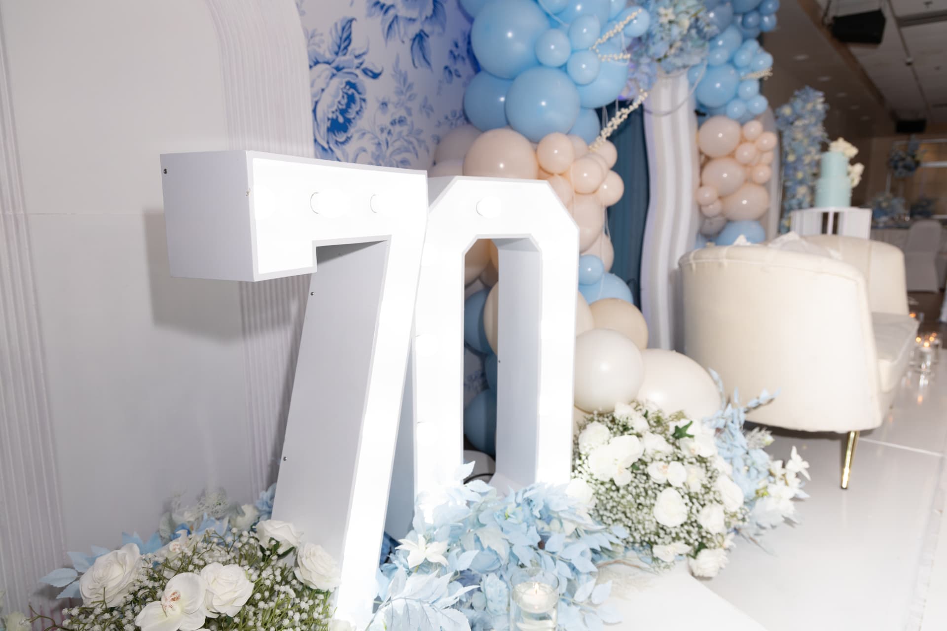 Marquee 70 sign with blue and cream balloons and white florals