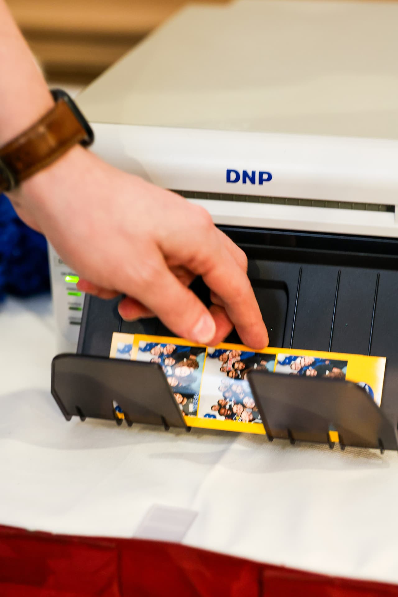 Attendant pulling a fresh photo strip from the booth printer